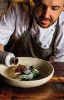  ??  ?? CHEF AT WORK ( RIGHT)
Crenn plating a dish of red snapper, local vegetables, black garlic jam, and dashi broth.