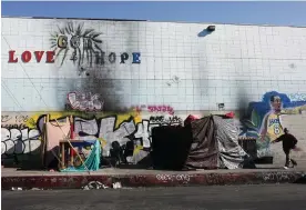  ?? Photograph: Mario Tama/Getty Images ?? A person walks past a homeless encampment on Skid Row in Los Angeles on 28 September 2023.