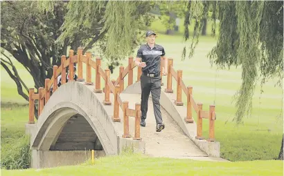  ?? Picture: Gallo Images ?? FOLLOW MY LEADER. Jacques Kruyswijk and his caddie cross a bridge during the first round of the Joburg Open at Randpark Golf Club yesterday.