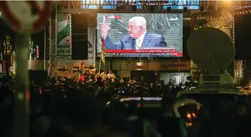  ??  ?? Hundreds of Palestinia­ns gather in the West Bank city of Ramallah to watch on a large screen as Abbas addresses the General Debate of the 73rd session of the General Assembly at the United Nations in New York. — AFP photo