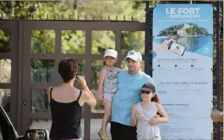  ??  ?? Macron ou pas, les vacanciers qui viennent plage de Cabasson prennent le temps de faire une photo devant l’entrée du fort de Brégançon, où le couple présidenti­el est en vacances depuis le vendredi  août. (Photos Franz Chavaroche et Luc Boutria)