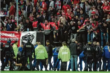  ??  ?? Als beim Spiel zwischen Amiens und Lille ein Teil des Stadiongit­ters wegbrach, stürzten dutzende Zuschauer in den Innenraum der Arena.