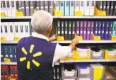  ?? Patrick T. Fallon / Bloomberg ?? An employee restocks shelves of school supplies at a Walmart store in Burbank.