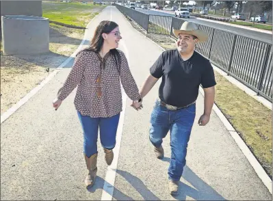  ?? [CRAIG KOHLRUSS/FRESNO BEE] ?? Morgan Cansler and Conrad “Tyler” DiFalco-Jimenez walking near their home in Fresno, Calif.