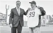  ?? MATT FREED/TRIBUNE NEWSPAPERS ?? Pittsburgh Pirates president Frank Coonelly recently presented usher Phil Coyne, 99, with an appropriat­e jersey.