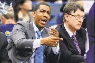  ?? Fred Beckham / Associated Press ?? Former UConn coach Kevin Ollie and associate head coach Glenn Miller watch a 2013 game in Hartford. Ollie has filed a lawsuit against , contending Miller slandered him in comments to the NCAA.