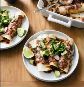  ?? DANIEL J. VAN ACKERE — AMERICA’S TEST KITCHEN VIA AP ?? This undated photo provided by America’s Test Kitchen in February 2019 shows Chicken Enchiladas in Brookline, Mass. This recipe appears in the cookbook “The Complete Slow Cooker.”