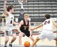  ?? ?? Prairie Grove sophomore Eric Henderson (black No. 3) works toward the goal guarded by Blackhawk junior Bric Cates (white No. 5) and sophomore Austin James (white No. 24) Tuesday, Feb. 8, in Blackhawk Arena. Pea Ridge won the boys basketball game 34-25.