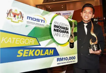  ??  ?? Ecstatic: A beaming Alif Imran posing with his award and trophy during the National Innovation Award (AIN) 2016 gala night.