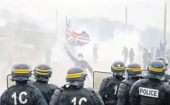  ?? Photograph: Reuters ?? Tear gas fills the air as French riot police face off with protesters in Calais yesterday