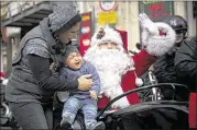  ?? ODED BALILTY / ASSOCIATED PRESS ?? A man dressed as Santa Claus waves from the sidecar of a motorcycle Sunday in Jerusalem’s Old City. Violence has flared over the U.S. decision to recognize Jerusalem as the capital of Israel.