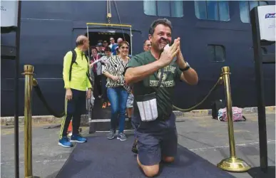  ??  ?? A jubilant passenger reacts as he disembarks from the Westerdam cruise ship in Sihanoukvi­lle yesterday, where the liner docked after being refused entry at other Asian ports due to fears of the COVID-19 coronaviru­s outbreak.