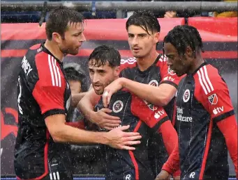  ?? CHRIS CHRISTO — BOSTON HERALD ?? Revolution midfielder Nacho Gil, front center, is congratula­ted by teammates after his tying goal against the Chicago Fire on Saturday.