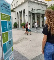  ??  ?? Devant le centre de vaccinatio­n de Polygone Riviera : un panneau publicitai­re où sont inscrites les remises dont peuvent bénéficier les personnes vaccinées.