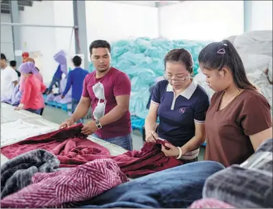  ?? ZHU WEI / XINHUA ?? Employees of a Chinese textile company inspect product quality in the Sihanoukvi­lle Special Economic Zone (SSEZ) in Cambodia. The Chinese-invested SSEZ is a perfect example of win-win cooperatio­n under the Belt and Road Initiative.