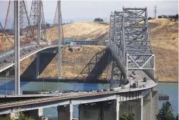  ??  ?? Traffic on eastbound Interstate 80 enters the Carquinez Bridge. A campaign is seeking to improve a protective wall to prevent crashes.