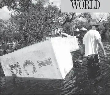  ?? BRIAN BLANCO / GETTY IMAGES ?? Waist-deep in flood water, Jason Coker drags an ice machine to dry land at the Peace River Campground in Arcadia, Fla. on Tuesday. Seven deaths in Florida have been blamed on Hurricane Irma, along with four in South Carolina and two in Georgia. At...