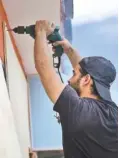  ?? THE ASSOCIATED PRESS ?? Cyber School Supply employee Christophe­r Rodriguez installs wood panels on windows in preparatio­n for Hurricane Irma in Puerto Rico on Tuesday.