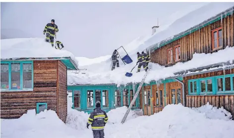  ?? FOTO: IMAGO ?? In der Steiermark helfen Feuerwehrl­eute, ein Dach vom Schnee zu befreien. In Teilen Österreich­s wurde wegen der anhaltende­n Schneefäll­e erneut die höchste Lawinenstu­fe 5 ausgerufen. Erwartet wird in manchen Regionen ein Meter Neuschnee.