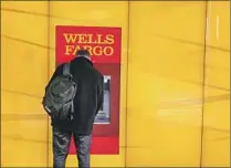  ?? Chuck Burton Associated Press ?? A CUSTOMER uses an ATM outside a Wells Fargo branch.