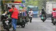  ??  ?? HANUNG HAMBARA/JAWA POS TAK HIRAUKAN RAMBU LARANGAN: Pedagang berjualan di sepanjang jalan Perumahan Taman Pinang Indah.