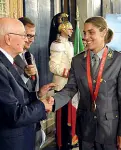  ??  ?? Giulia Quintavall­e con la divisa della Guardia della Finanza al Quirinale con l’allora presidente della Repubblica Napolitano