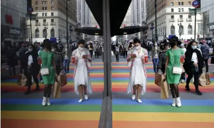  ?? Photograph: John Angelillo/UPI/Rex/Shuttersto­ck ?? Pedestrian­s walk on the sidewalk covered in the colors of the rainbow in New York City. LGBTQ+ workers make up about 7% of the population.