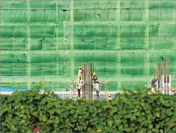  ?? HONG MENEA ?? Constructi­on workers at a building site yesterday on Phnom Penh’s Koh Pich.