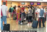  ??  ?? QUEUE: Poles wait to fly to Britain