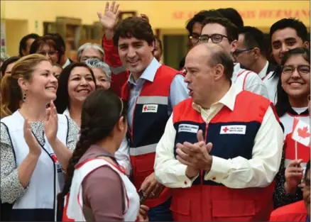  ?? SEAN KILPATRICK, THE CANADIAN PRESS ?? Justin Trudeau and wife Sophie Grégoire Trudeau (left) visit with Red Cross chief Fernando Cardenas and workers in Mexico City on Thursday.