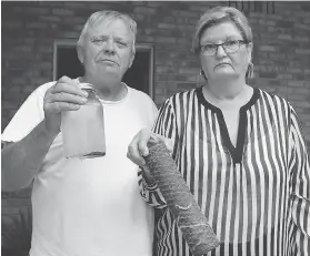  ?? ELLWOOD SHREVE ?? Wayne and Valerie Brooksbank hold a water sample and filter from their well to illustrate the amount of sediment that showed up in their water shortly after pile-driving began near their home.