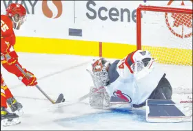  ?? Larry Macdougal The Associated Press ?? Devils goaltender Vitek Vanecek readies to stop a shot by Flames defenseman Noah Hanifin in New Jersey’s 4-3 overtime victory.