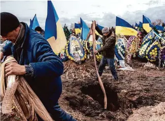  ?? Daniel Berehulak/New York Times ?? Cemetery workers bury the coffin of Ukrainian soldier Oleksiy Lytvynov during his funeral Sunday in Boryspil near Kyiv, Ukraine.