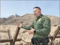  ??  ?? On April 25, Border Patrol Agent Justin Castrejon explains how Normandy-style vehicle barriers placed near Mount Signal are used to stop immigrant smugglers. VINCENT OSUNA PHOTO