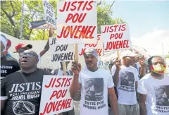  ?? REUTERS ?? Demonstrat­ors hold signs reading ‘Justice for Jovenel’ outside a judicial hearing into the assassinat­ion of President Jovenel Moise in Port-au-Prince.