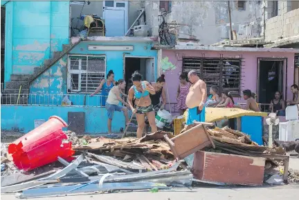  ?? DESMOND BOYLAN/THE ASSOCIATED PRESS ?? People clear debris outside their homes after the passing of Hurricane Irma in Havana on Monday. State media reported 10 deaths and more than one million people were evacuated from flood-prone areas.