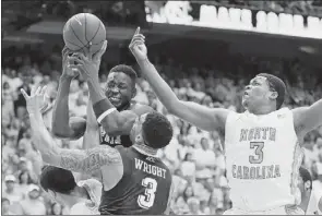  ?? Karl B DeBlaker/Associated Press ?? Talib Zanna and Cameron Wright battle North Carolina’s Marcus Paige and Kennedy Meeks for the ball Feb. 15 in Chapel Hill, N.C. North Carolina won, 75-71.