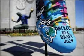  ?? CARLOS OSORIO — THE ASSOCIATED PRESS ?? An NFL football draft cleat is displayed near the Spirit of Detroit statue on Friday in Detroit. The draft has taken the show on the road for a decade, giving cities a chance around the country a chance to be in the spotlight.