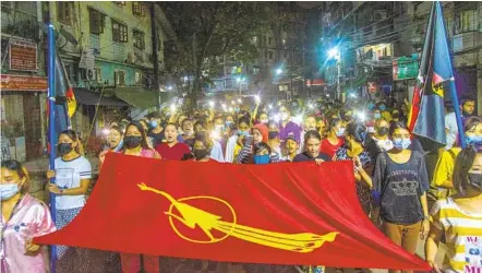  ?? AP ?? Residents display a banner with an insignia of the National League of Democracy party of deposed Myanmar leader Aung San Suu Kyi during an anti-coup rally held despite an overnight curfew Monday at the Myaynigone area of Sanchaung township in Yangon, Myanmar.