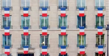  ?? JACKY NAEGELEN/REUTERS ?? L’omaggio.
Bandiere francesi alle finestre di un edificio vicino a Invalides (in alto) dove ieri François Hollande (in basso a sinistra) ha commemorat­o in una cermonia di stato le 130 vittime della strage di venerdì 13 novembre davanti alle famiglie e...