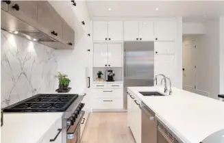  ??  ?? Left Ikea cabinetry is jazzed up with handforged metal knobs. The focus of the kitchen is the marble backsplash, which sees two book-matched slabs meet in the middle. Above the stove, the recessed cabinets frame the alcove nicely