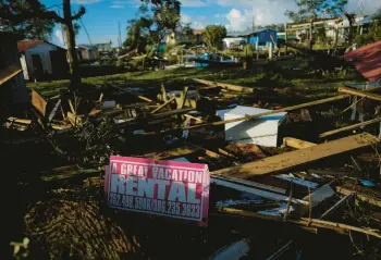  ?? REBECCA BLACKWELL/AP ?? A sign advertisin­g a vacation rental lies amid scattered debris Thursday in Horseshoe Beach, Florida.