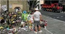  ?? REUTERS/MARKO DJURICA ?? A man looks at floral tributes for the victims of the Grenfell Tower fire outside the Notting Hill Methodist Church, in London.