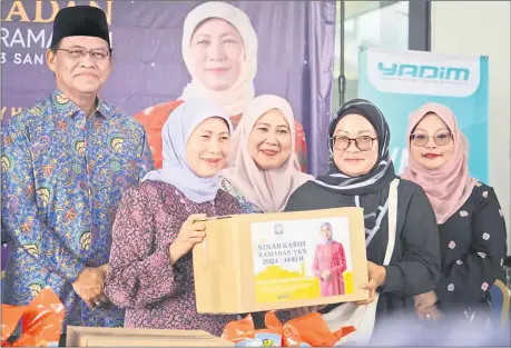  ?? ?? Nancy (front, left) presents a food basket to a recipient. Seen behind the federal minister is Dr Abdul Rahman (left).