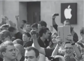  ?? SEAN GALLUP/GETTY IMAGES ?? The days of Apple enthusiast­s, like these at a store opening in Berlin Friday, may be waning, David Olive writes.