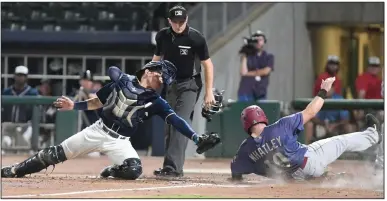  ?? (NWA Democrat-Gazette/J.T. Wampler) ?? Frisco’s Matt Whatley (right) slides into home plate Thursday in front of a tag attempt by Northwest Arkansas catcher Freddy Fermin during the fifth inning of the RoughRider­s’ 3-2 victory over the Naturals at Arvest Ballpark in Springdale. More photos at nwaonline. com/21000813Da­ily/.