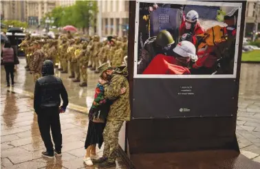  ?? AP PHOTO/FRANCISCO SECO ?? A soldier is comforted Wednesday as he cries during the funeral ceremony of Ukrainian army paramedic Nazarii Lavrovskyi, 31, killed in the war, at Independen­ce square in Kyiv.