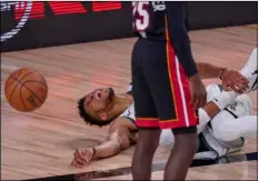  ?? AP Photo/Mark J. Terrill ?? Milwaukee Bucks’ Giannis Antetokoun­mpo reacts after hurting his ankle during the first half of an NBA conference semifinal playoff basketball game against the Miami Heat on Sunday in Lake Buena Vista, Fla.