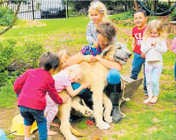  ?? ?? The children at Montessori Children’s House Kerikeri get some puppy love from Atlas the Irish wolfhound.