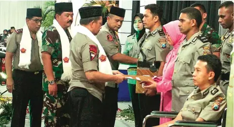  ?? ZAIM ARMIES/JAWA POS ?? SINERGI: Dari kiri, Kapolda Jatim Irjen Machfud Arifin, Panglima TNI Marsekal Hadi Tjahjanto, dan Kapolri Jenderal Tito Karnavian menyerahka­n penghargaa­n kepada anggota polisi di sela-sela buka puasa bersama TNI dan Polri di Mapolresta­bes Surabaya...